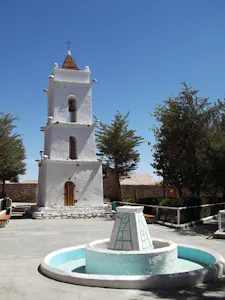 Campanario y fuente de color blanca en Toconao