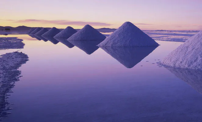 Conos de sal se reflejan sobre el agua durante la mejor época para visitar el Salar de Uyuni