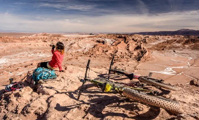Viajera toma agua y descansa junto a su bicicleta en Atacama