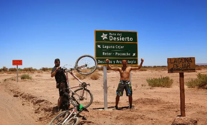 Viajero sostiene una bicicleta en caminos del desierto de Atacama