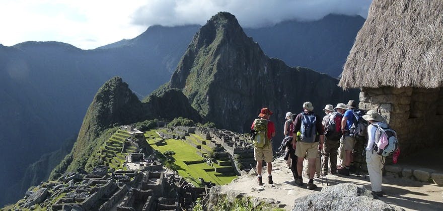 Grupo de viajeros observando restos arqueológicos de machu picchu