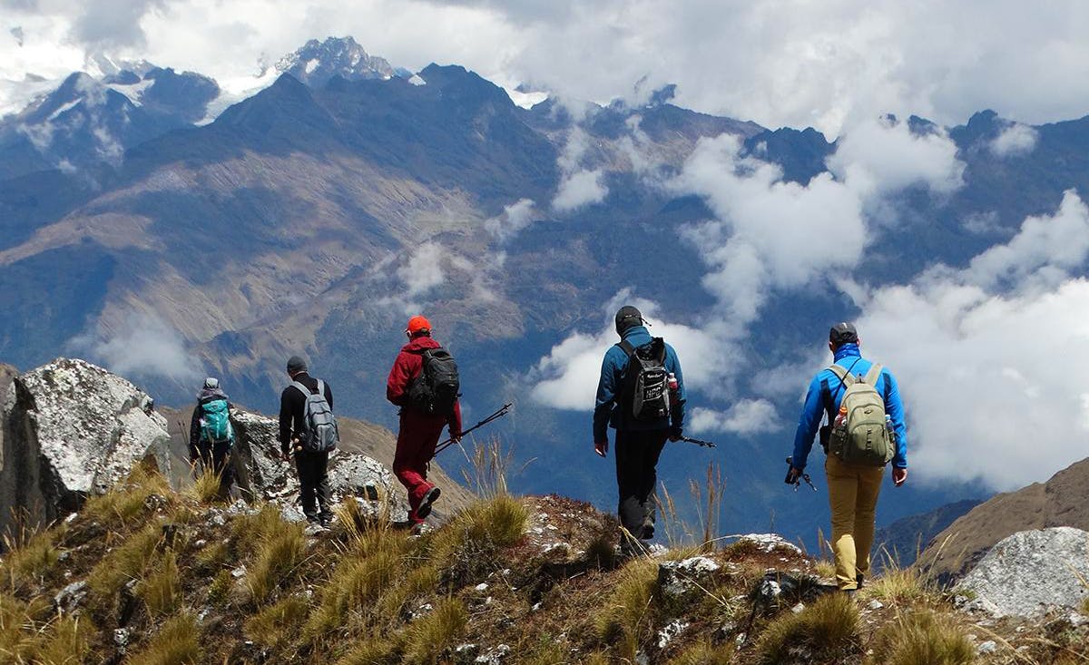 Viajeros caminan frente a montañas