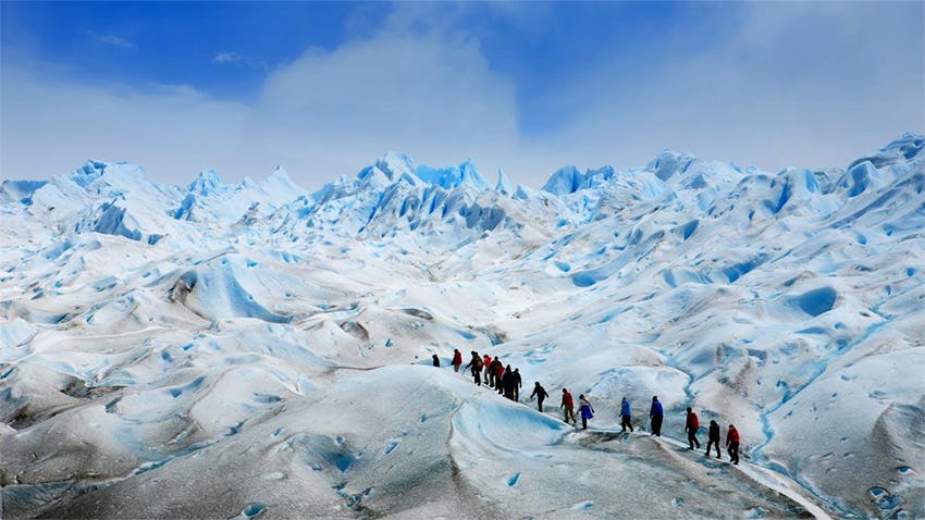 viajeros realizan caminata sobre glaciar