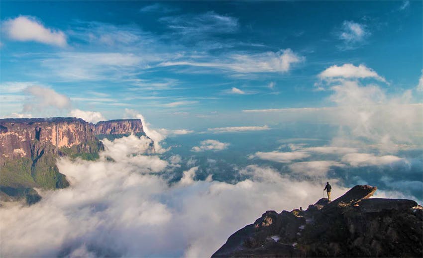 Viajero observa desde la cima de un monte