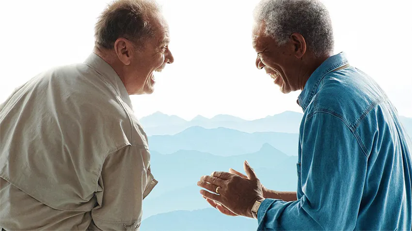 Dos hombres riendo frente a paisaje montañoso