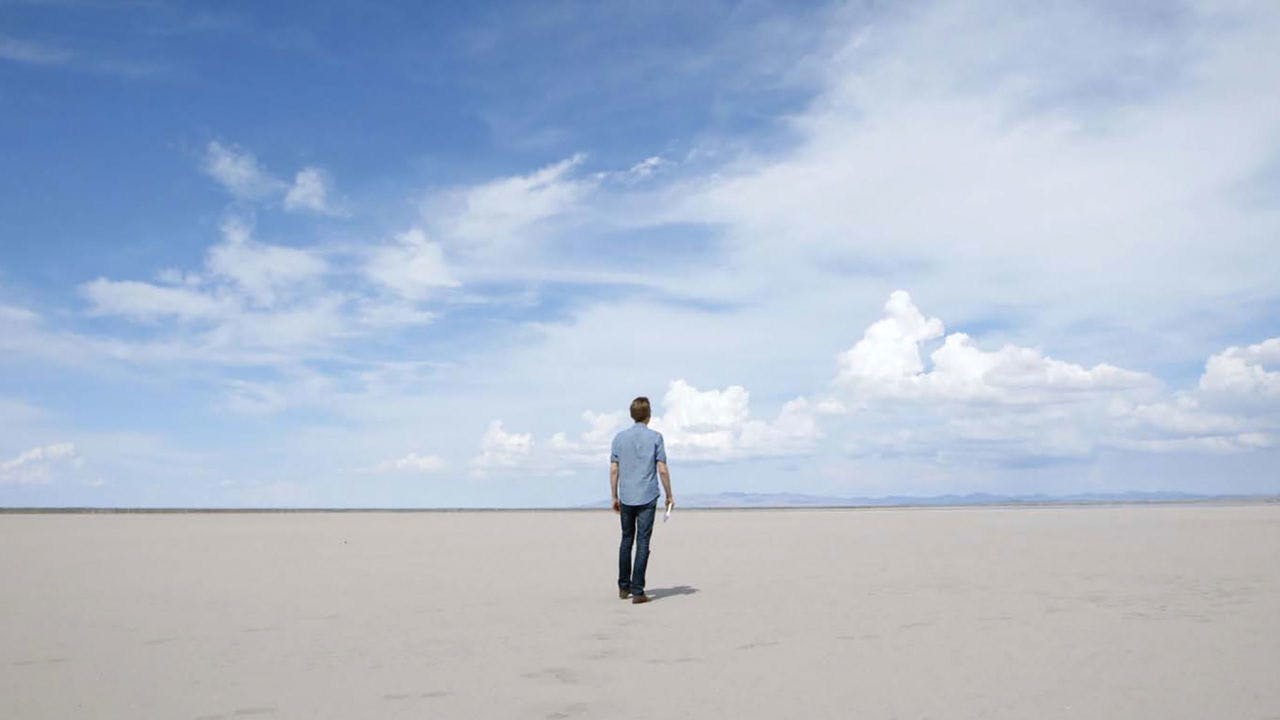 Hombre frente a desierto desolado