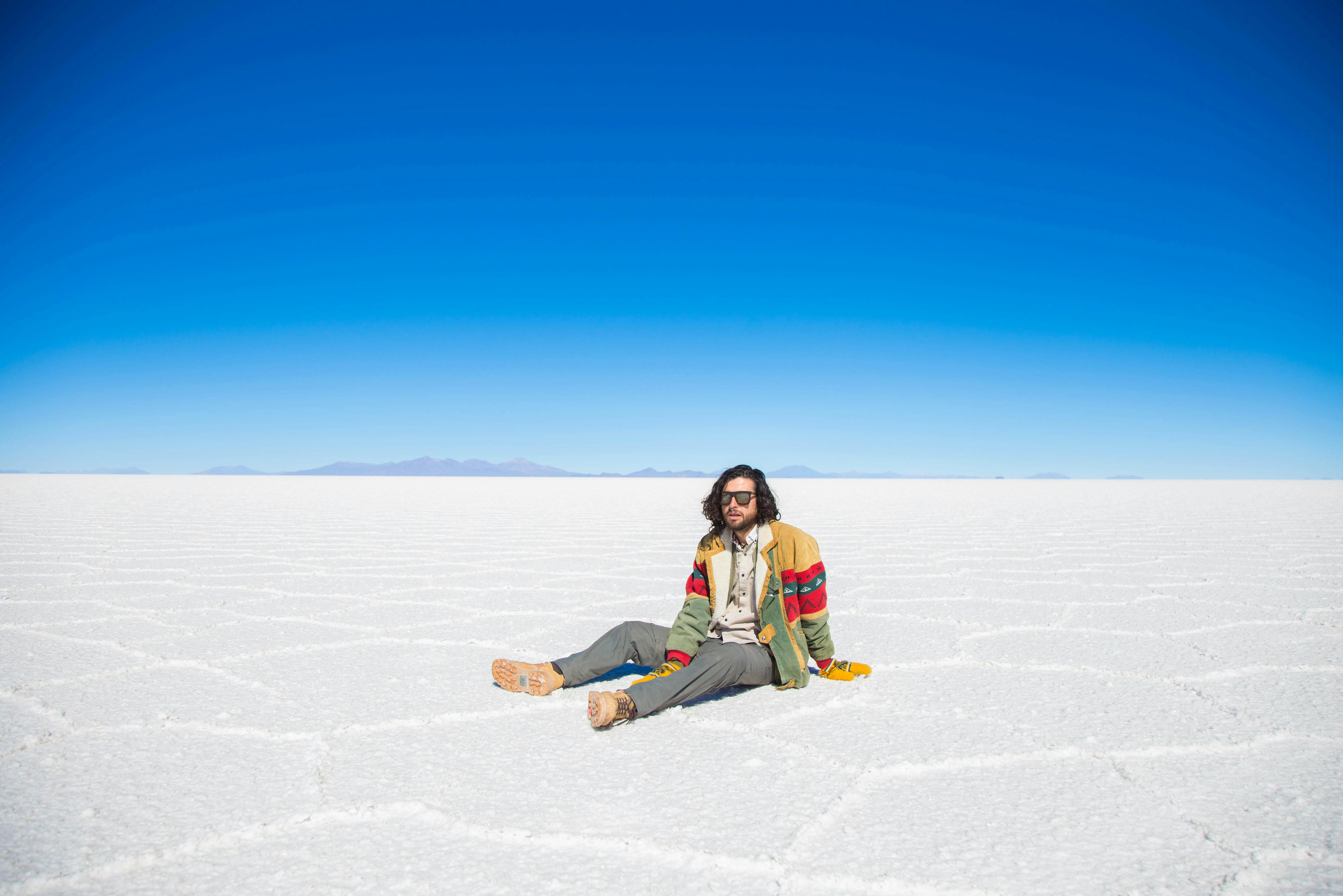 Hombre sentado en salar de uyuni