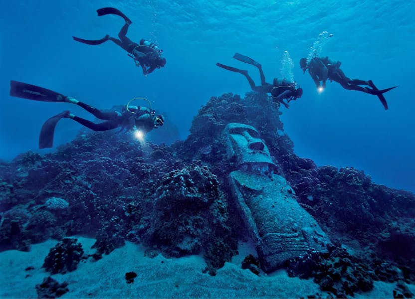 Buzos alrededor de moai sumergido