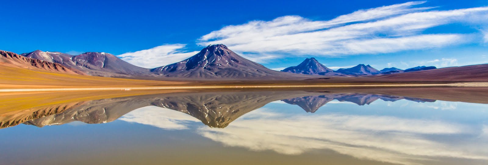 Volcanes frente a laguna reflejados en el agua