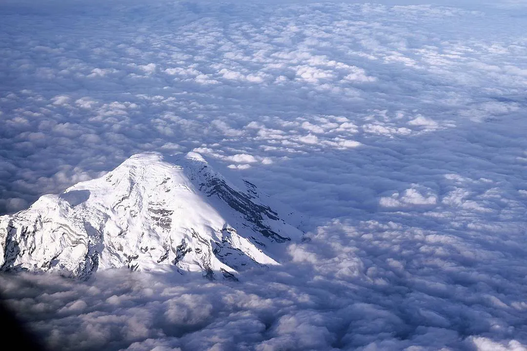Volcan nevado por encima de las nubes