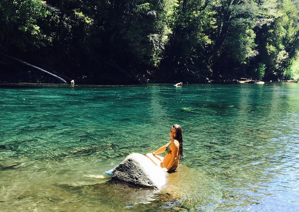 Mujer bañandose a la orilla del río