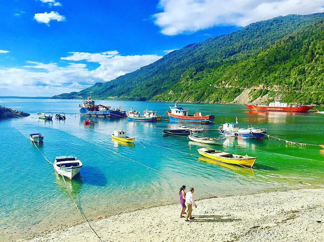 Barcos y personas en la orilla de una caleta