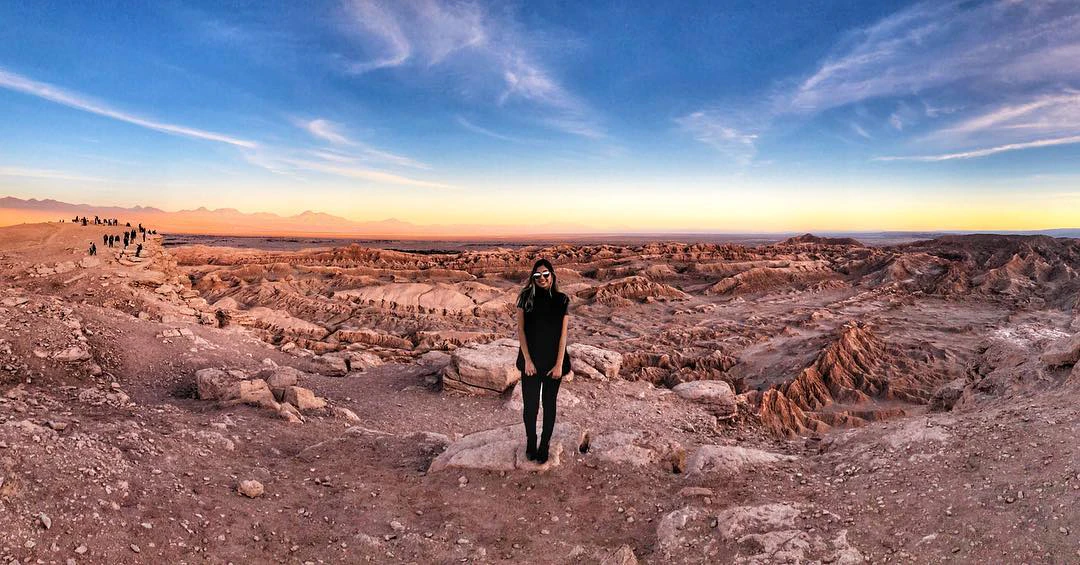 Viajera parada sobre valle rocoso en Atacama