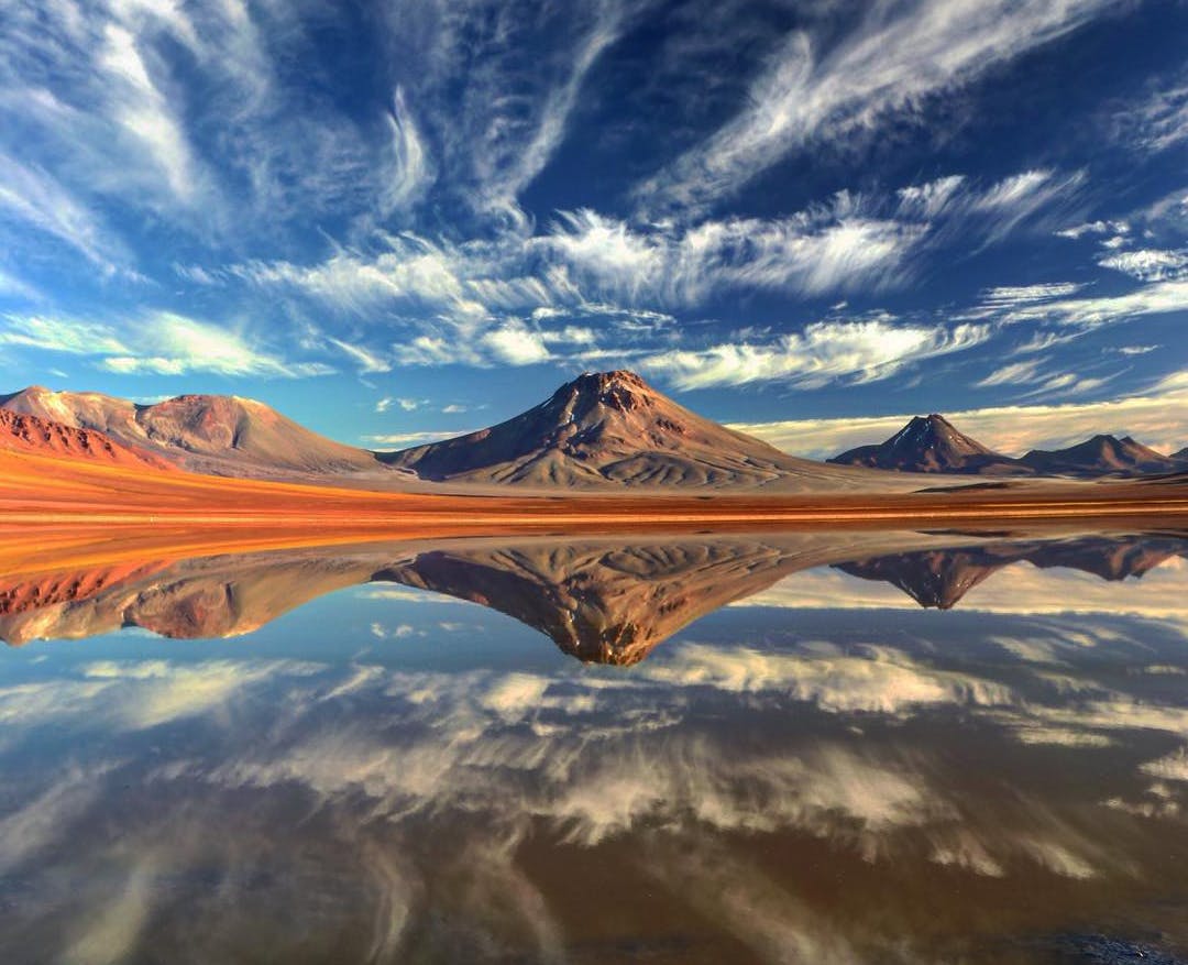 Volcanes y laguna reflejada con el cielo