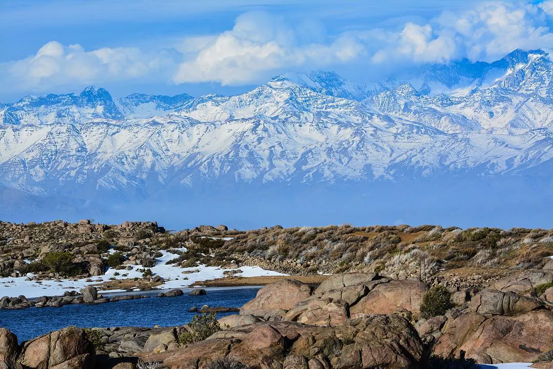 Laguna, rocas y cordillera de fondo
