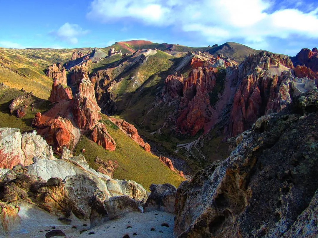 Montañas verdes con gigantes rocas rojas