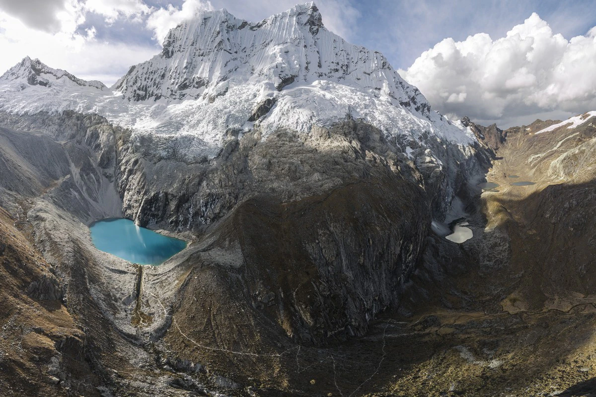 Laguna de color turquesa bajo montaña nevada