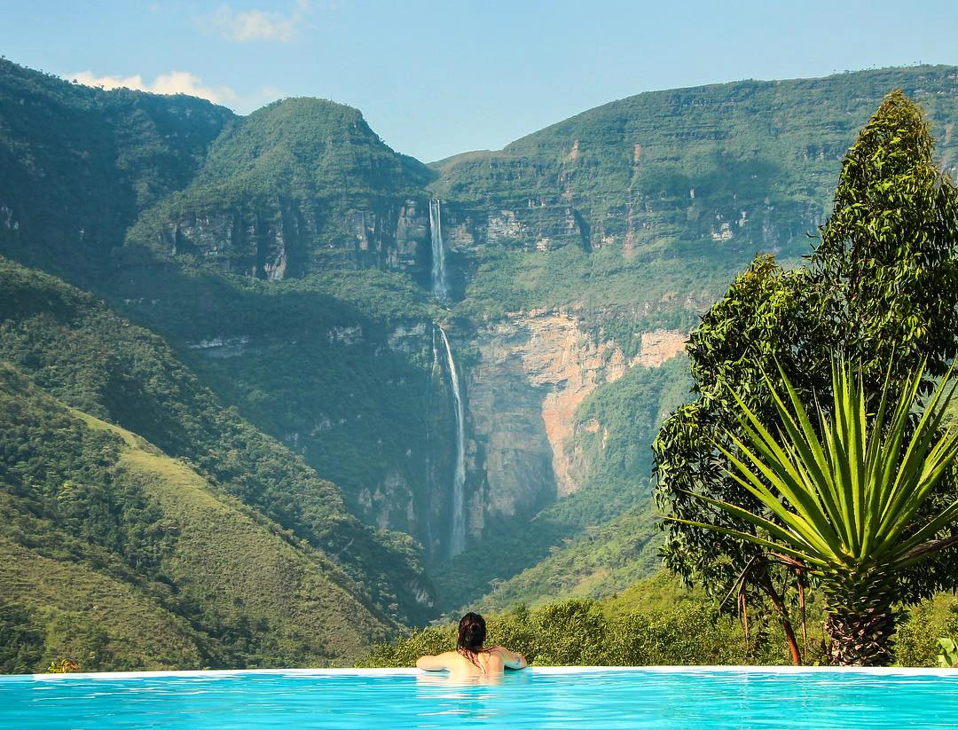 Mujer en piscina frente a catarata