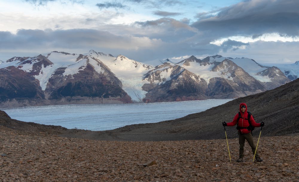 Viajero frente a glaciar y montañas en circuito o