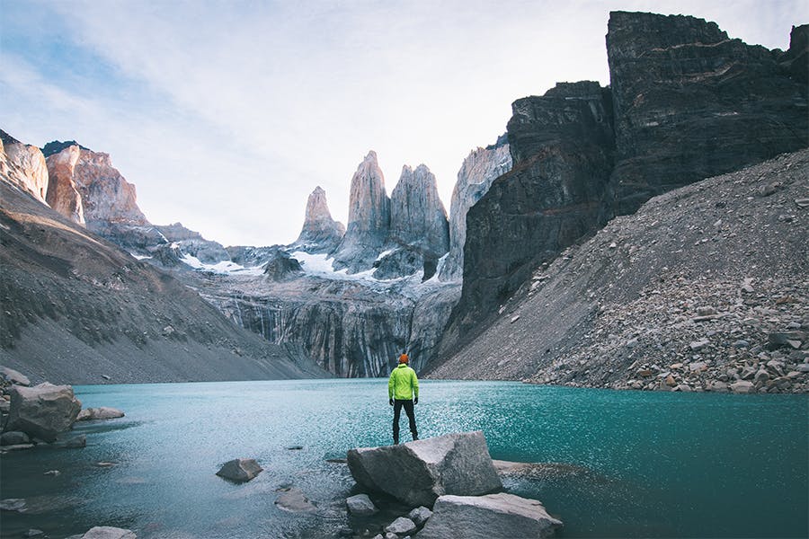 Viajero parado frente a muros de granito en Base Torres, el parque nacional más popular según tripadvisor