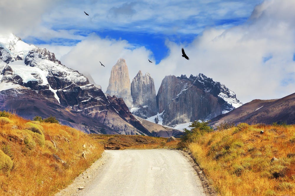 Camino de tierra en dirección a montañas