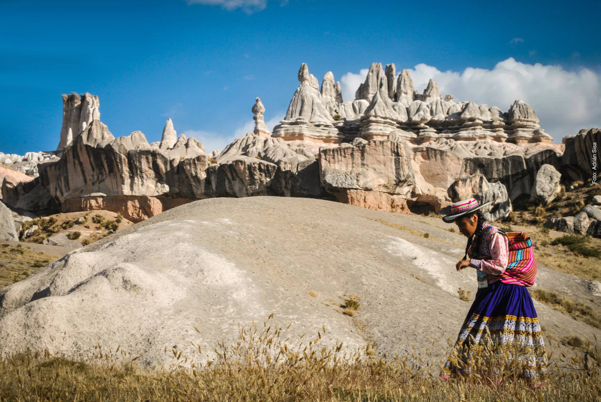 Mujer caminando frente a bosque de piedras