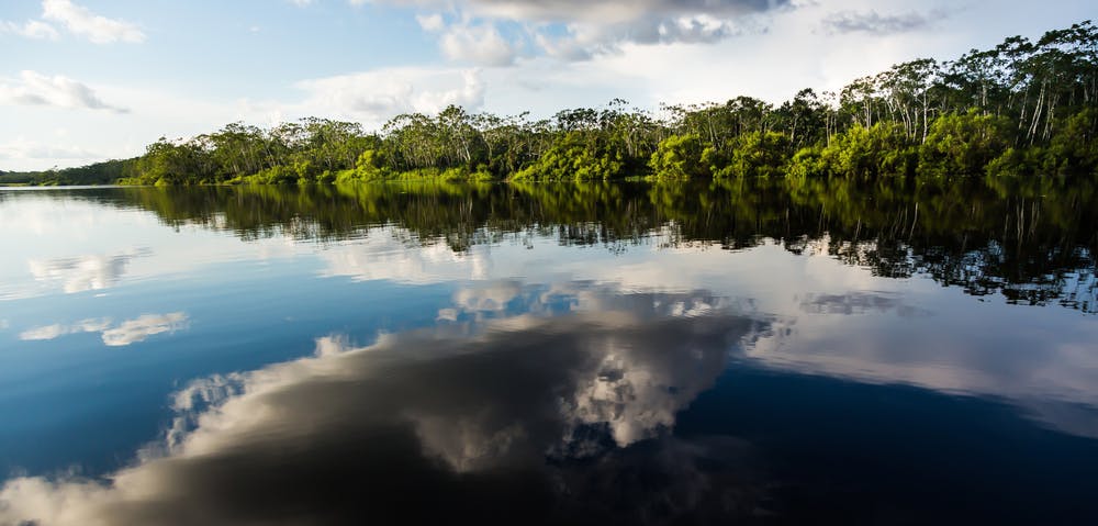 Reflejo de nubes sobre un río en la selva de puerto maldonado en perú