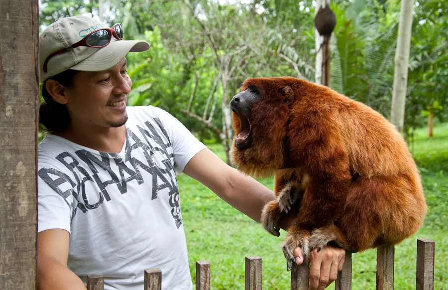 Hombre sosteniendo a mono en la selva peruana