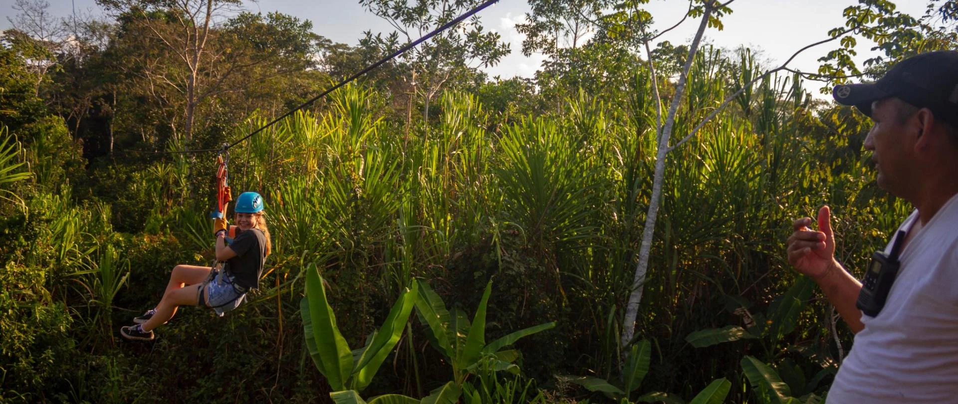 Niña realizando canopy en la selva