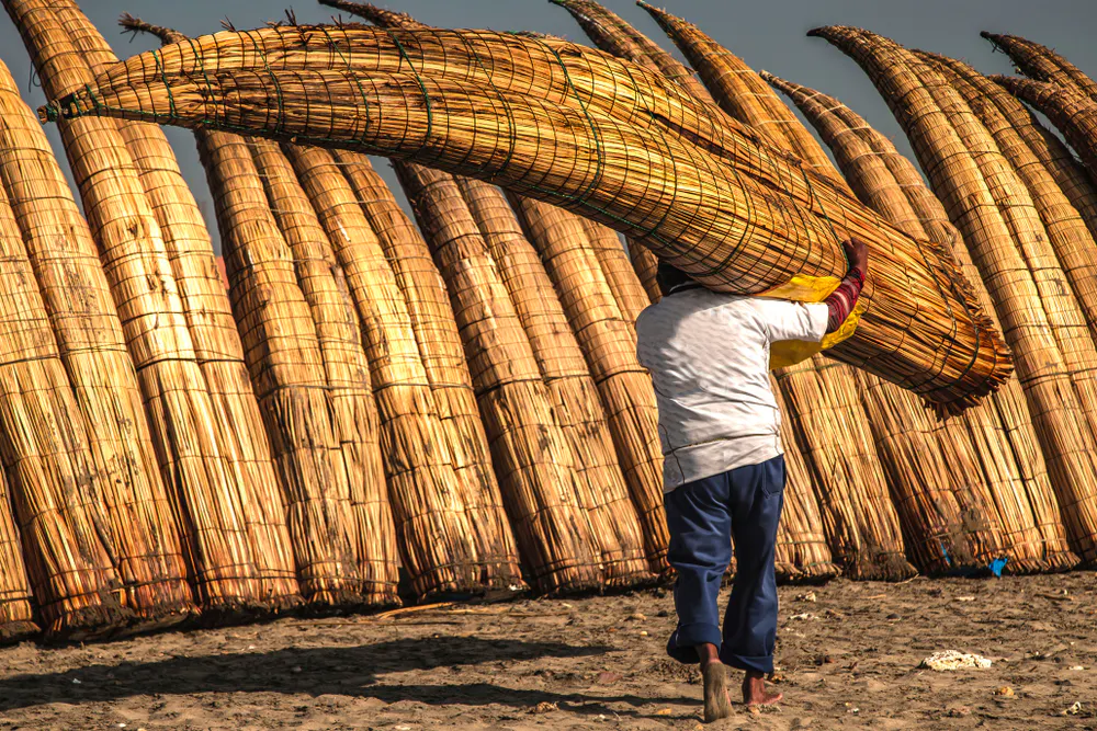 caballitos-totora Hombre transportando caballito de totora