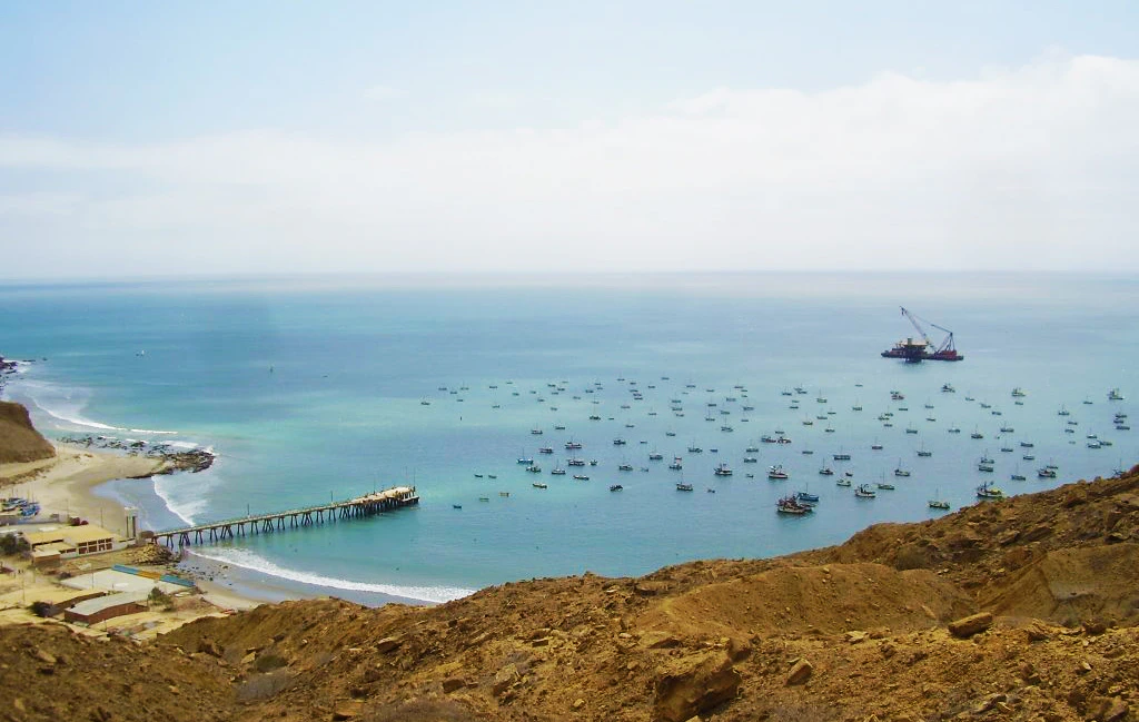 Playa con aguas cristalinas y botes de pescadores