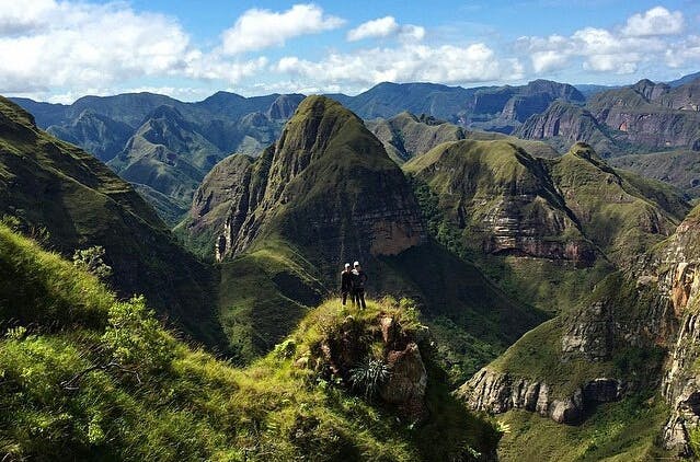 Pareja en frente a paisaje montañoso y de vegetación