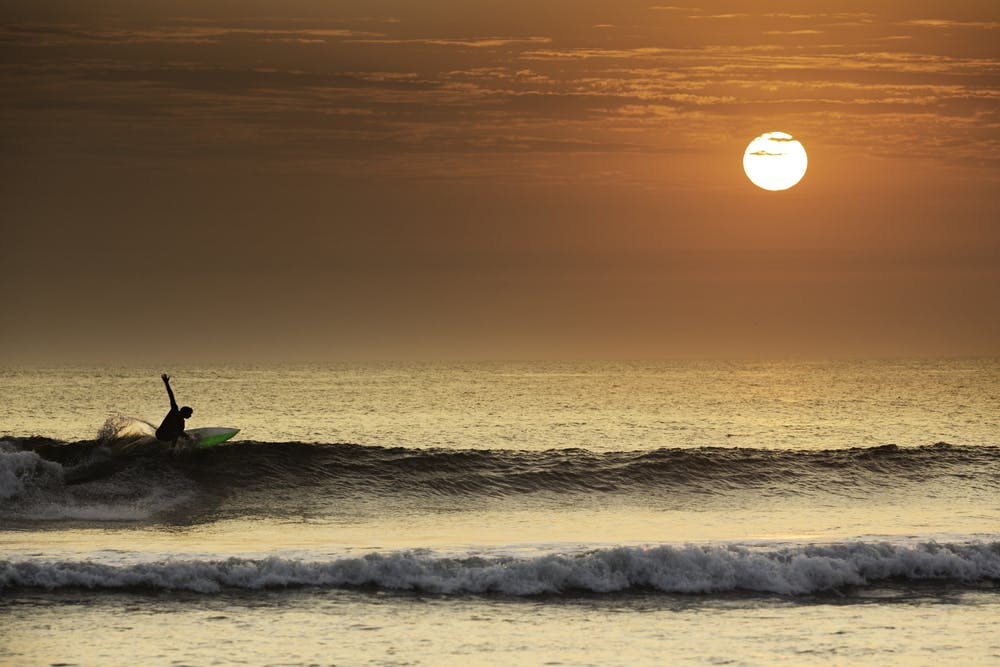 Surfista en el mar durante el atardecer