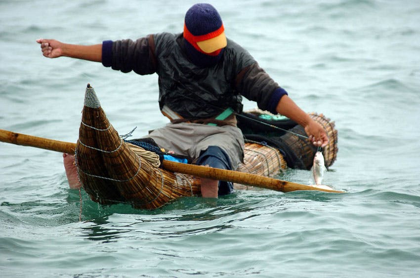 Pescador arriba de caballito de totora en huanchaco