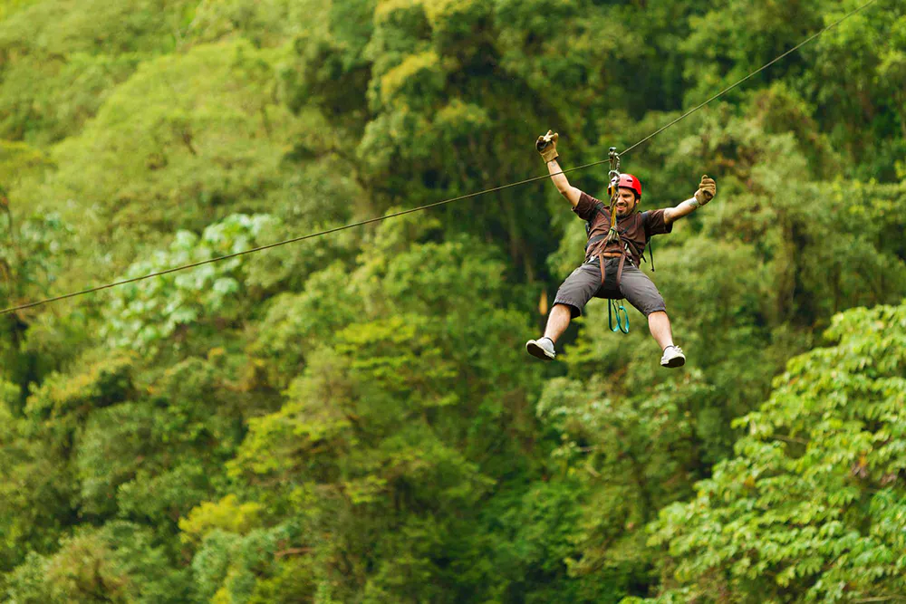 Hombre bajando en zipline en la selva de tambopata