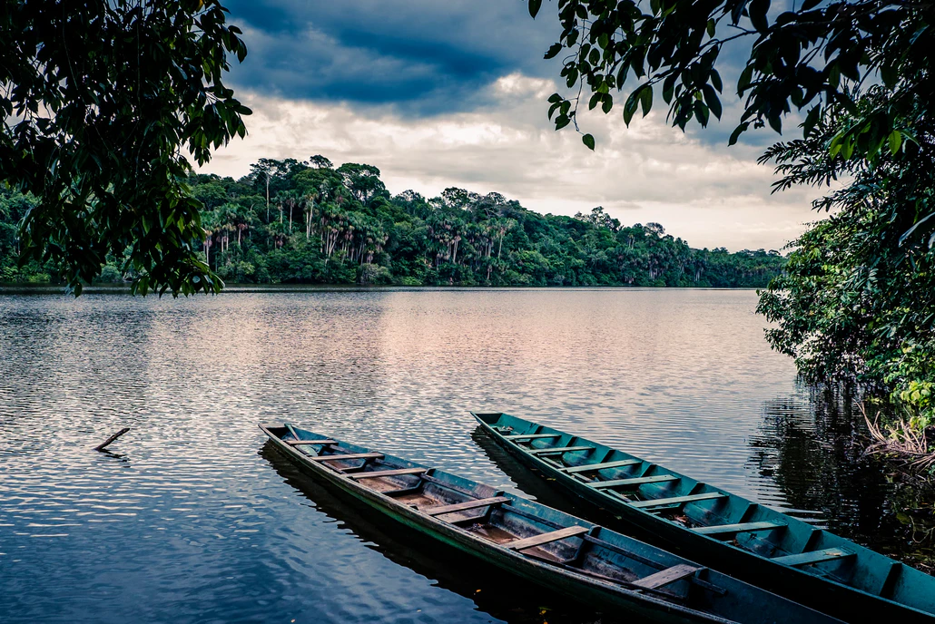 Dos canoas en lago durante el atardecer en Tambopata