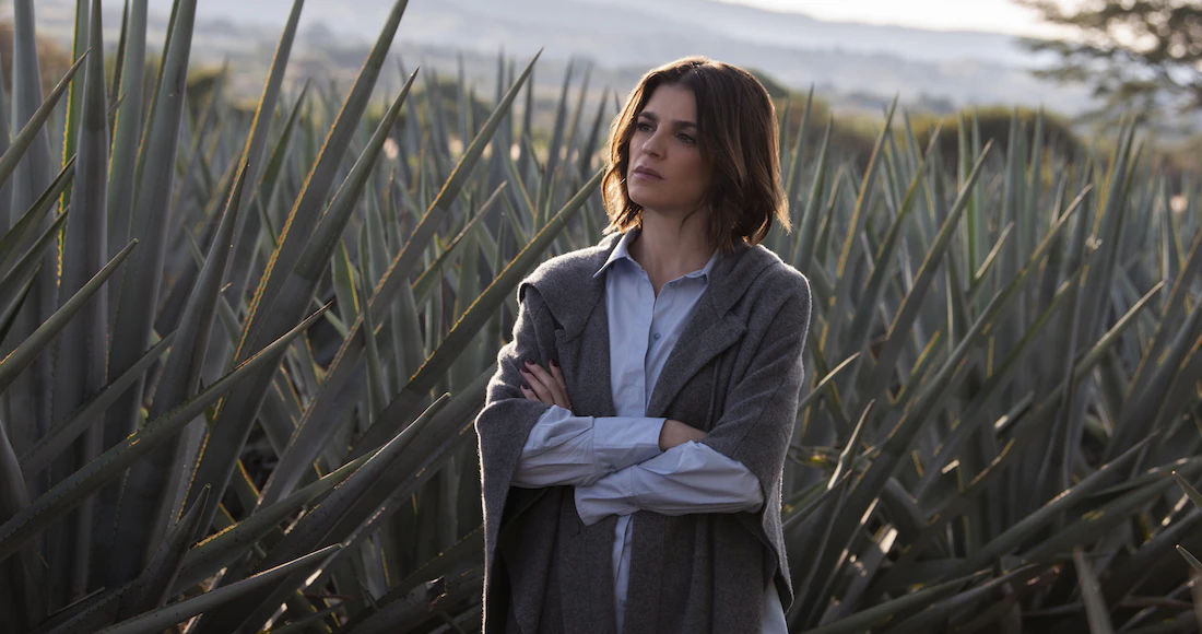 Mujer enmedio de plantaciones de tequila