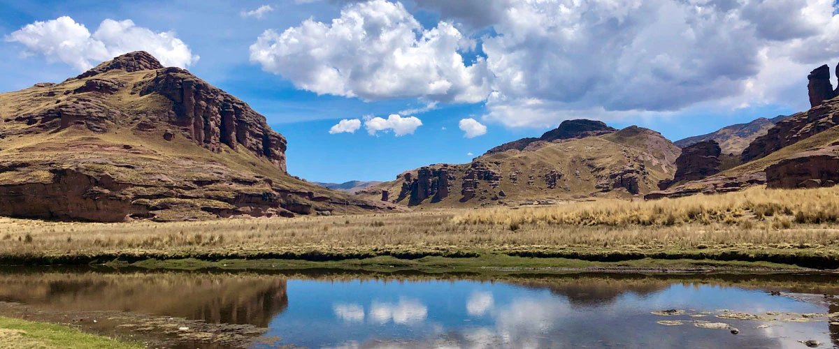 Pequeña laguna grente a inmenso cañón en Perú