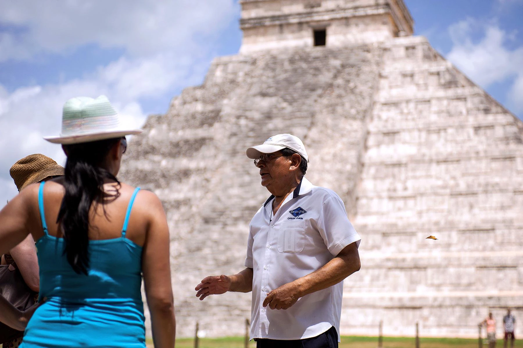 Guía turístico explica a viajeros en Chichen Itzá