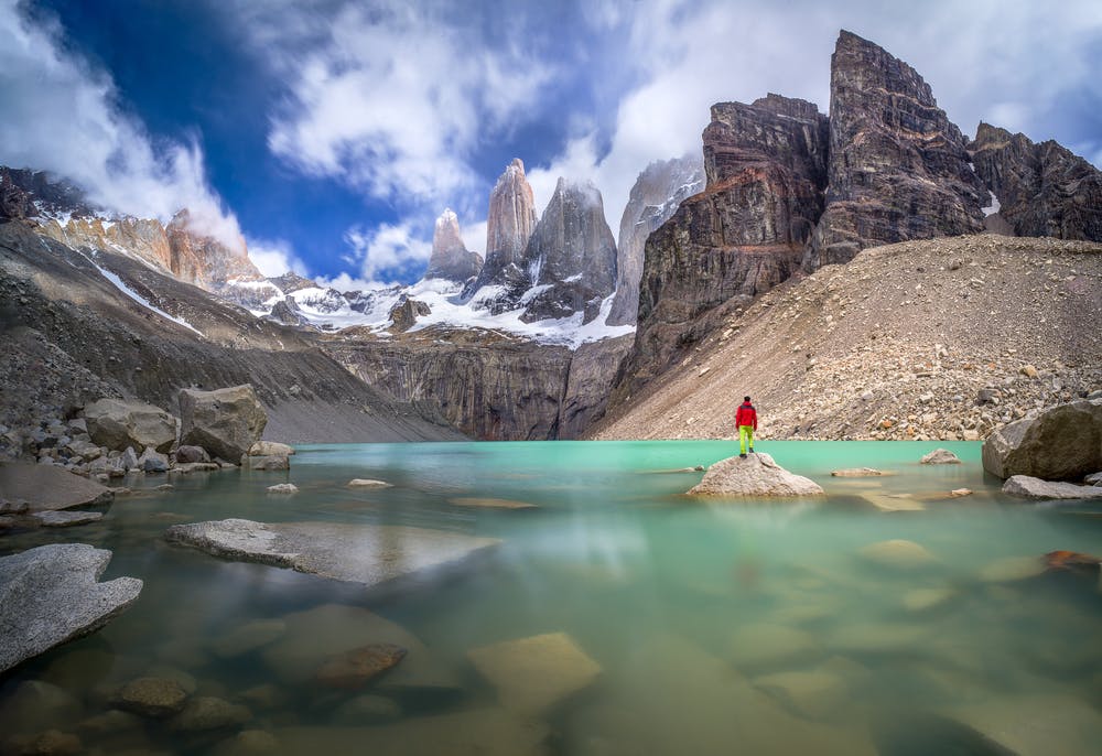 Viajero en chaqueta roja observando torres del paine