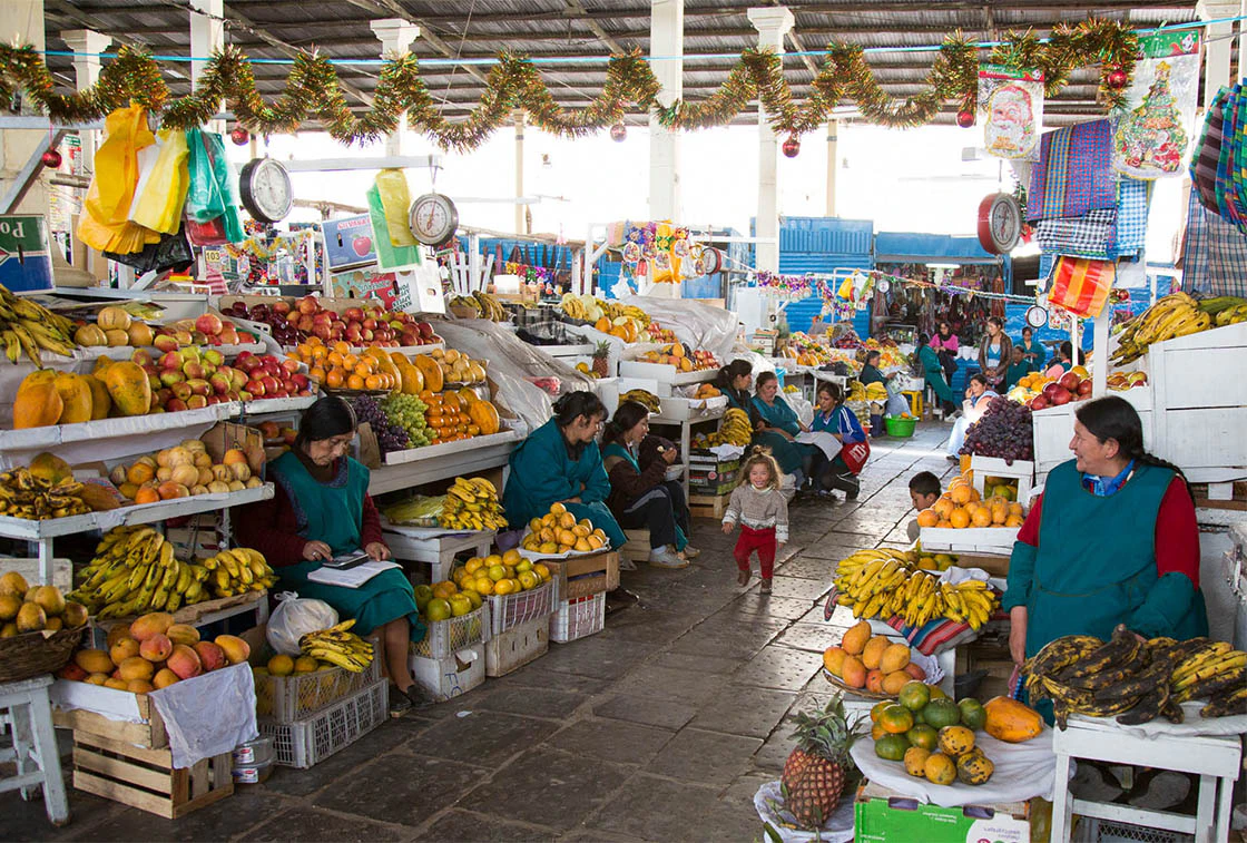 Feria de frutas y señoras sentadas