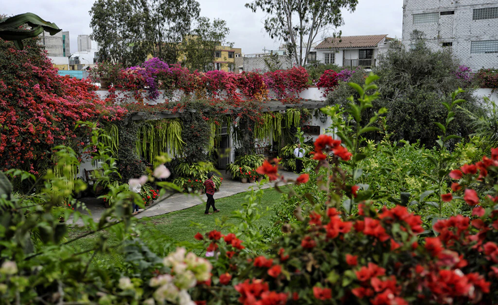 Mujer caminando por bello jardín en Lima