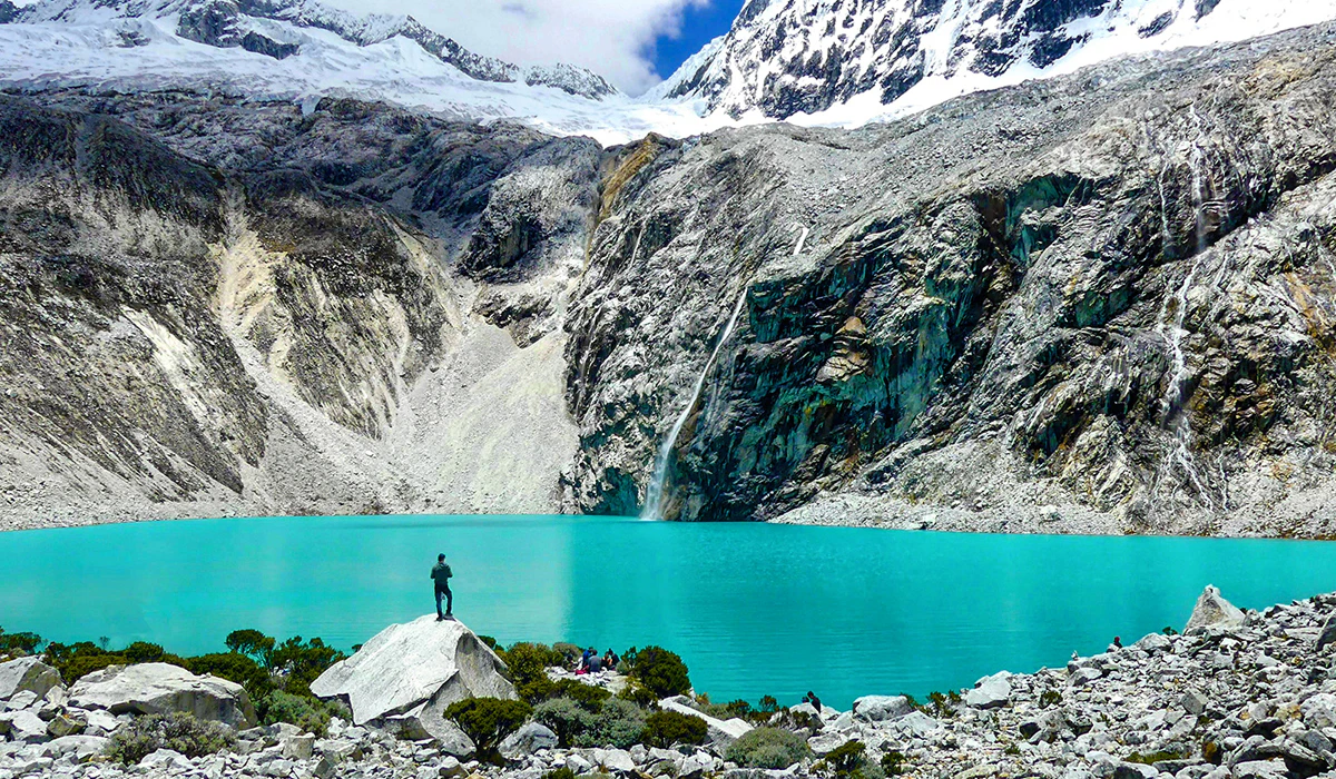 Laguna de color turquesa bajo montaña en Huaraz