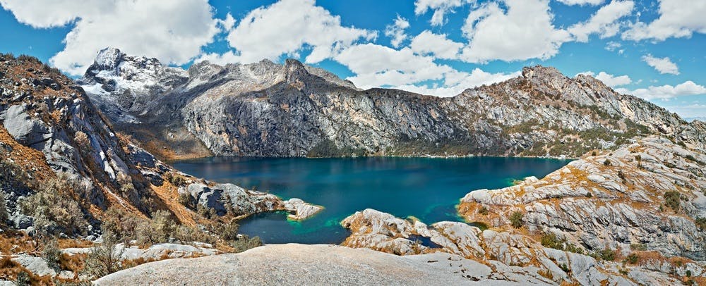 Laguna color azul profundo y montañas al fondo