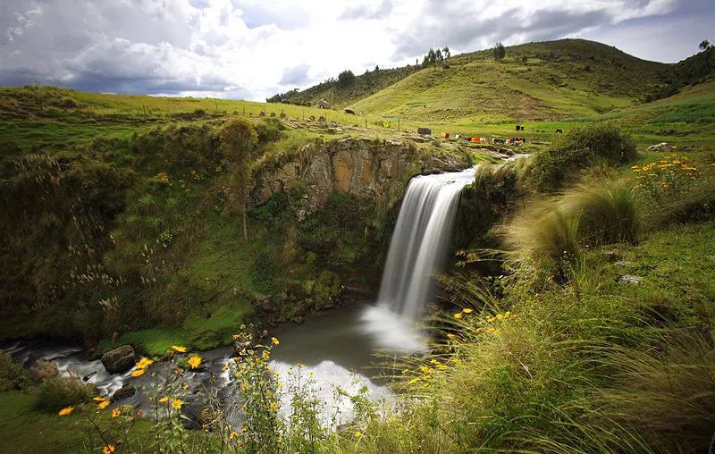 Cascada rodeada de amplio paisaje y leve vegetación