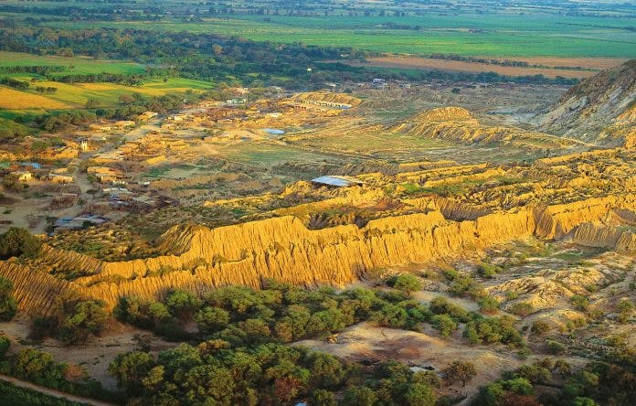 Pirámides de tierra en medio de paisaje con vegetación