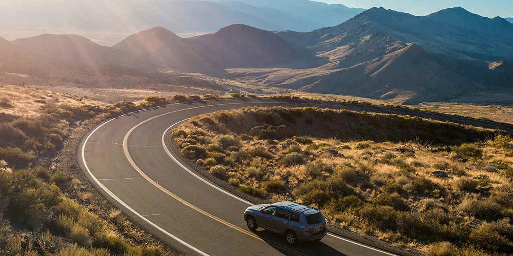 Carro viajando por la carretera y de fondo montañas