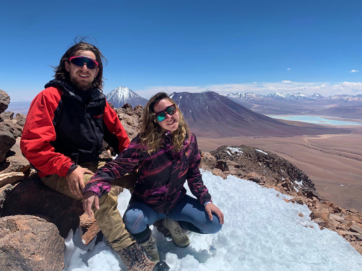 Pareja de viajeros en la cima de un volcán