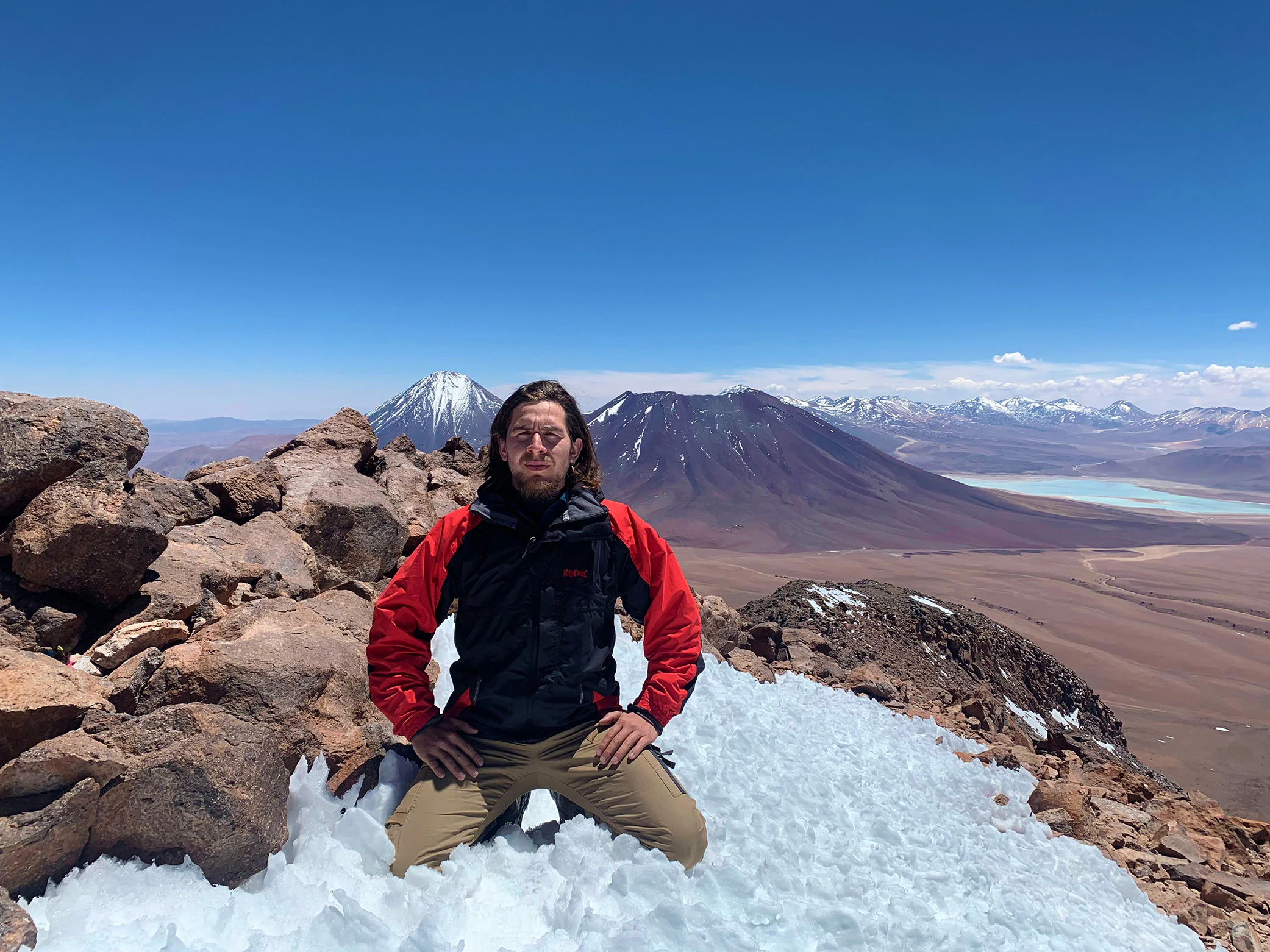 Hombre en la cima de volcan en el desierto