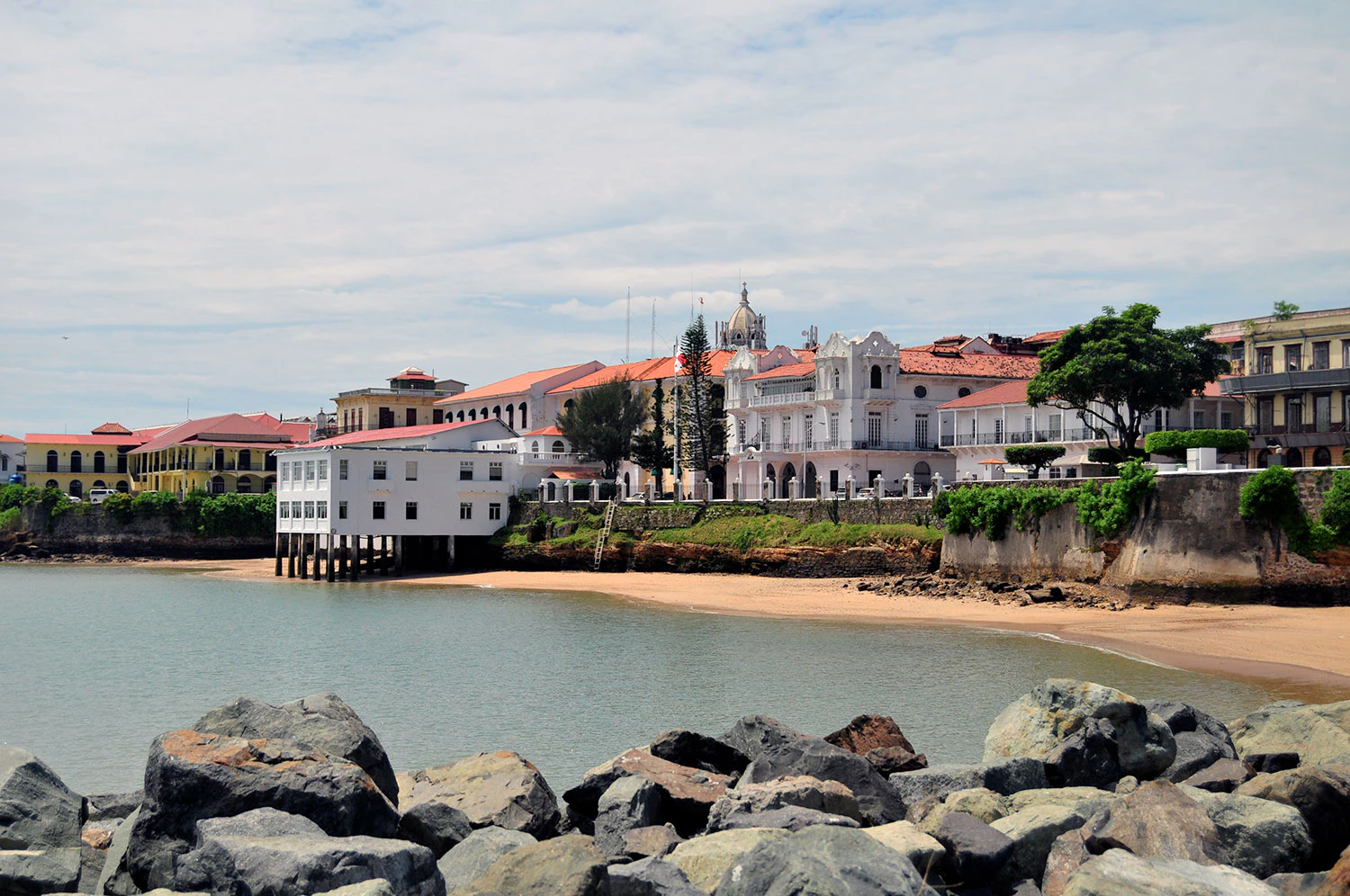 Ciudad colonial con edificios blancos frente a una playa